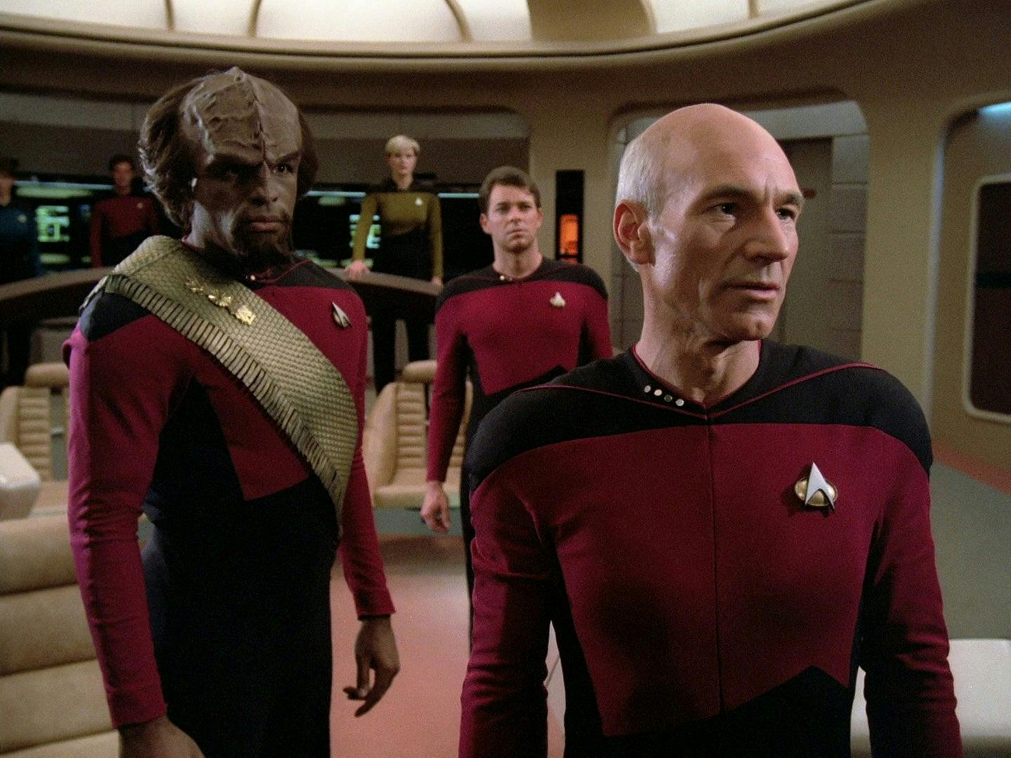Worf beside Picard on the Enterprise bridge. I use a real Star Trek Klingon to make the next world in the verse visible; the line does not name Worf.
