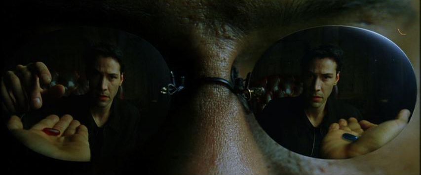 Morpheus’s glasses hold Neo and both pills in the same frame. In The Matrix, Neo chooses red. I hear Lupe’s “both” rewriting that choice.